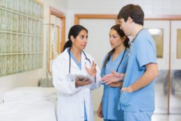 female-doctor-talking-to-a-male-and-a-female-nurse-in-a-hallway